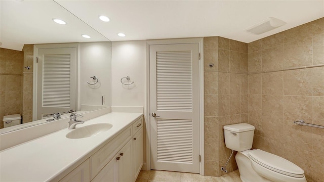 bathroom featuring tile patterned floors, tile walls, a closet, and vanity