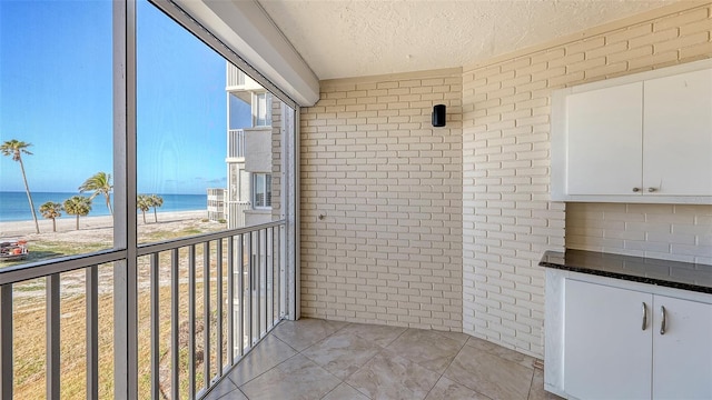 balcony with a water view and a beach view