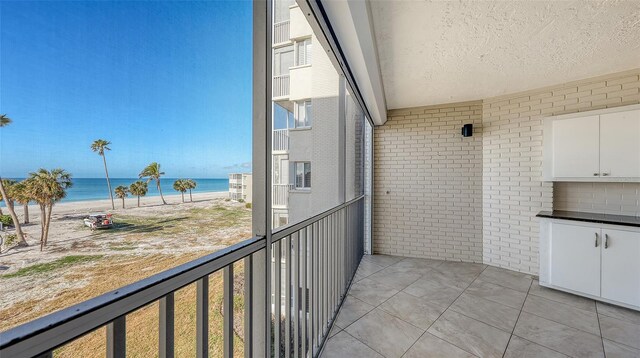 balcony featuring a water view and a view of the beach