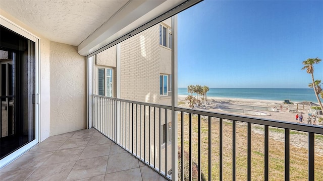 balcony featuring a water view and a view of the beach