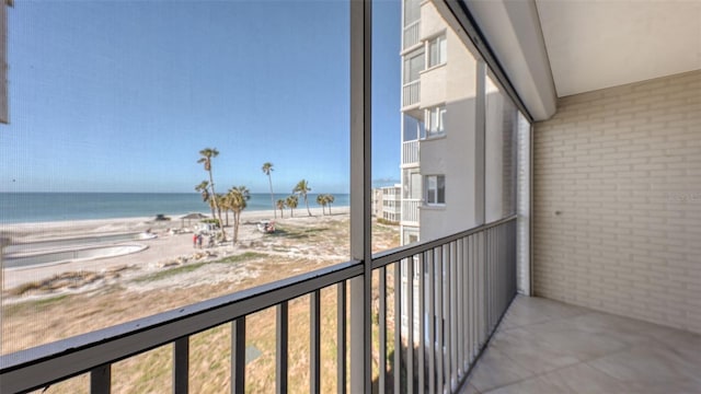 balcony featuring a water view and a beach view