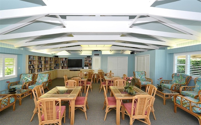 carpeted dining space with lofted ceiling with beams