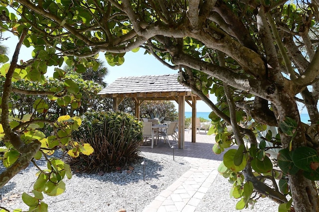 surrounding community with a patio area, a gazebo, and a water view