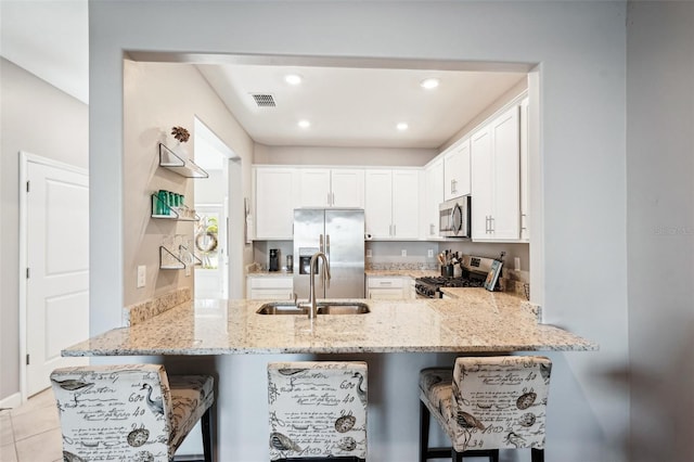 kitchen featuring kitchen peninsula, stainless steel appliances, a breakfast bar area, and sink