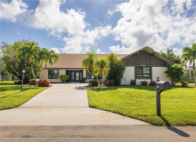 single story home featuring french doors and a front lawn