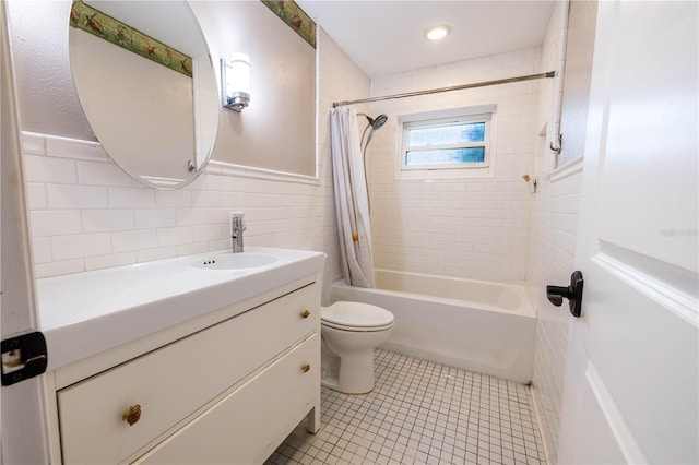 full bathroom with vanity, shower / bath combination with curtain, tile patterned flooring, toilet, and tile walls