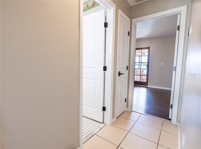 hall with light tile patterned floors