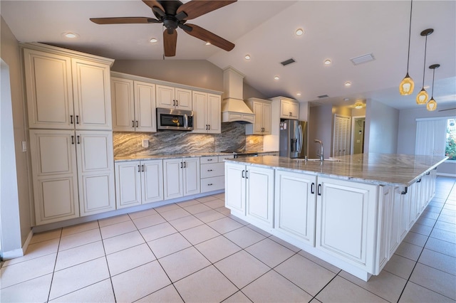 kitchen featuring appliances with stainless steel finishes, custom range hood, vaulted ceiling, a spacious island, and hanging light fixtures