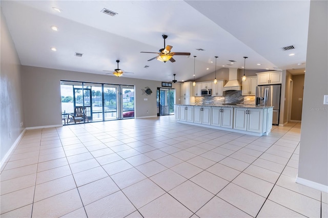 unfurnished living room featuring light tile patterned floors, vaulted ceiling, and ceiling fan