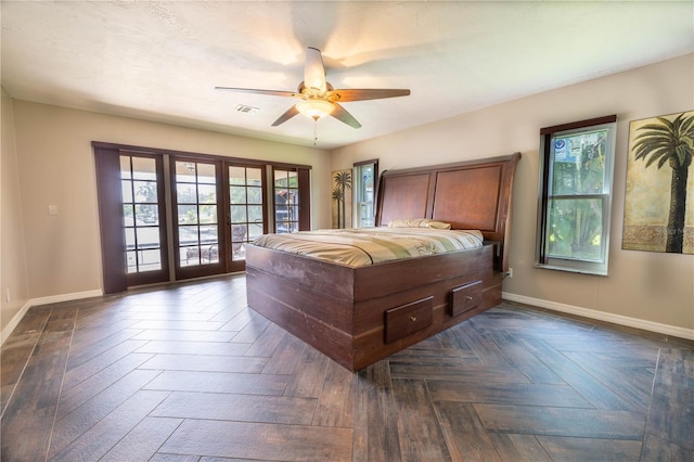 bedroom with dark parquet flooring, ceiling fan, and access to exterior