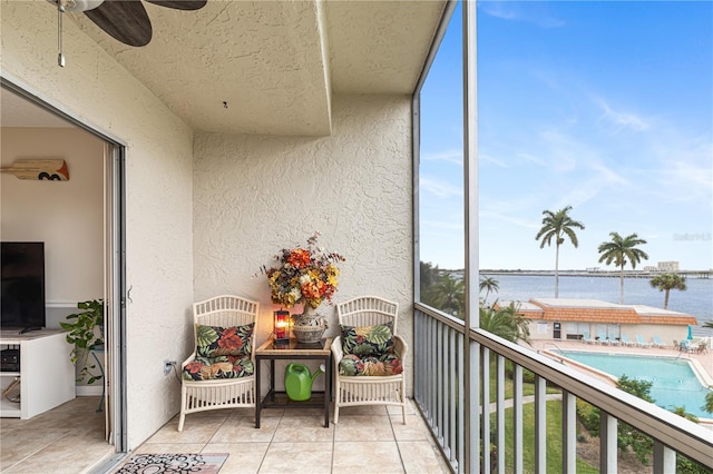 balcony with a water view and ceiling fan