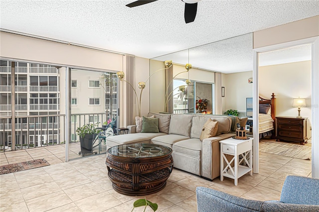 tiled living room with ceiling fan, a healthy amount of sunlight, and a textured ceiling