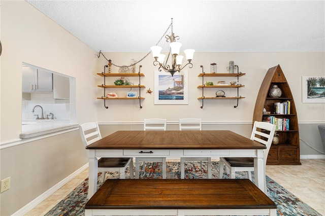 dining space with tile patterned flooring, a textured ceiling, a notable chandelier, and sink