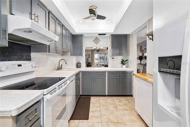 kitchen featuring gray cabinets, light tile patterned flooring, white appliances, and sink