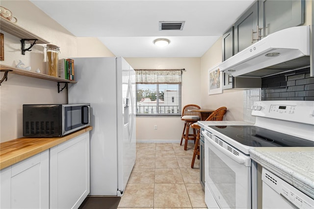 kitchen featuring tasteful backsplash, butcher block countertops, white appliances, gray cabinets, and light tile patterned floors