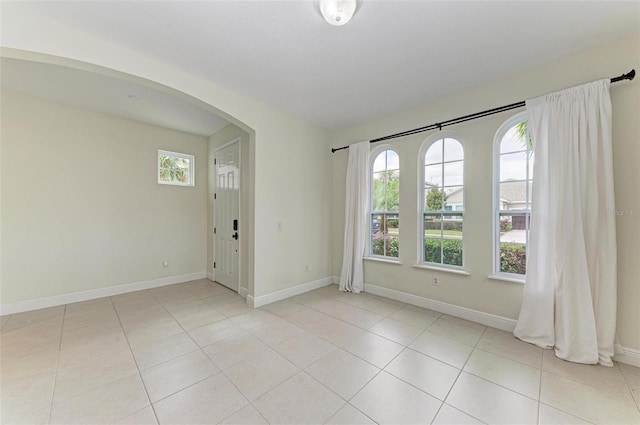 unfurnished room featuring light tile patterned floors and a wealth of natural light