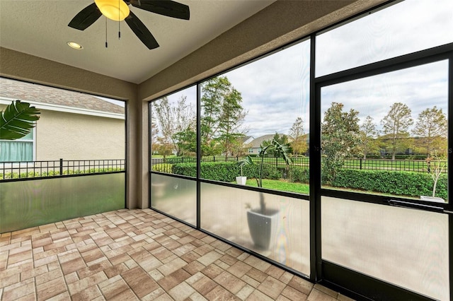 unfurnished sunroom featuring ceiling fan