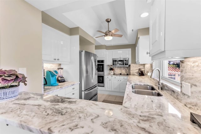 kitchen with decorative backsplash, sink, white cabinets, and appliances with stainless steel finishes