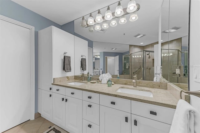 bathroom featuring tile patterned flooring, vanity, and a shower with shower door