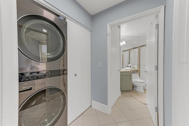 washroom with light tile patterned floors and stacked washer and dryer