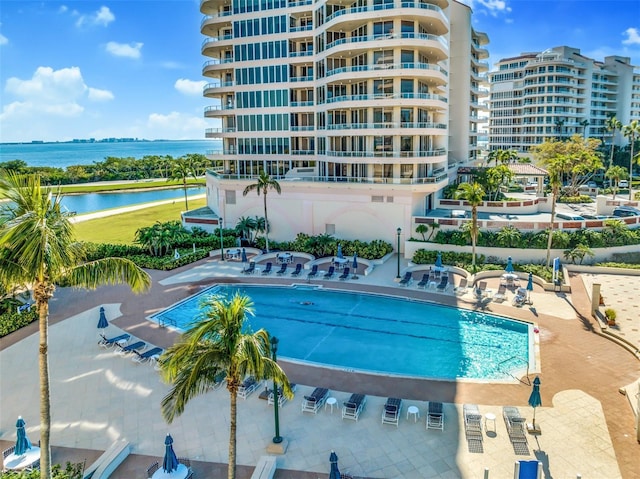 view of pool with a water view and a patio