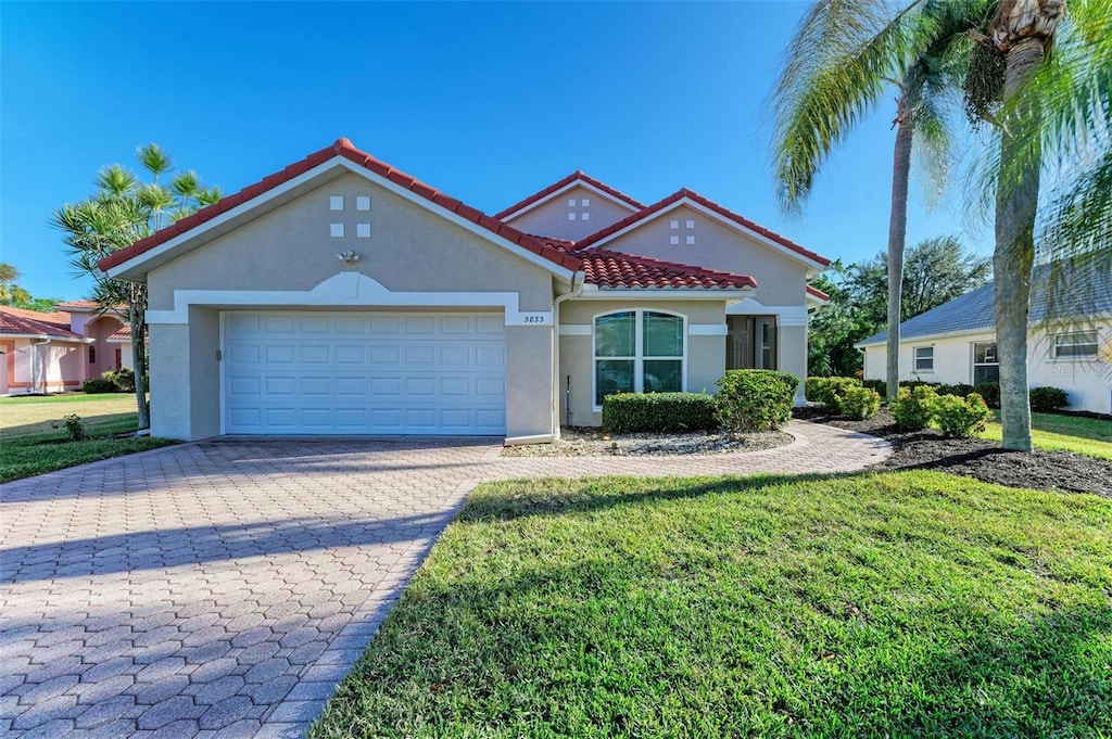 view of front of home with a front yard and a garage