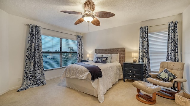 bedroom featuring a textured ceiling, ceiling fan, and carpet