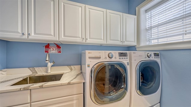 laundry room with sink, independent washer and dryer, and cabinets