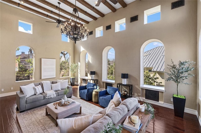 living room featuring beam ceiling, a towering ceiling, plenty of natural light, and hardwood / wood-style floors