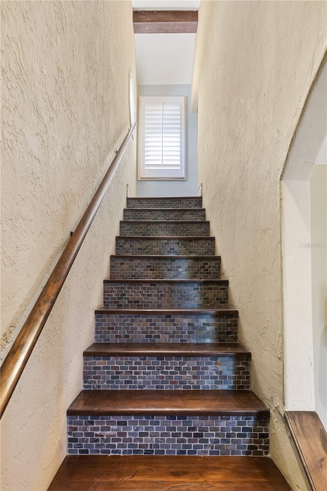 8855 Midnight Pass Rd, Sarasota, FL 34242 - stairway featuring a textured wall and wood finished floors