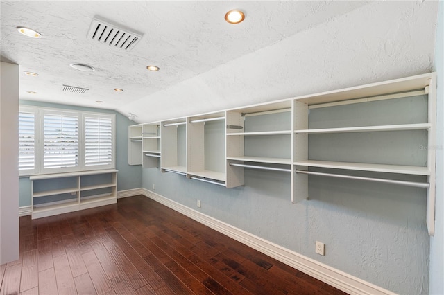 walk in closet with dark hardwood / wood-style floors and lofted ceiling