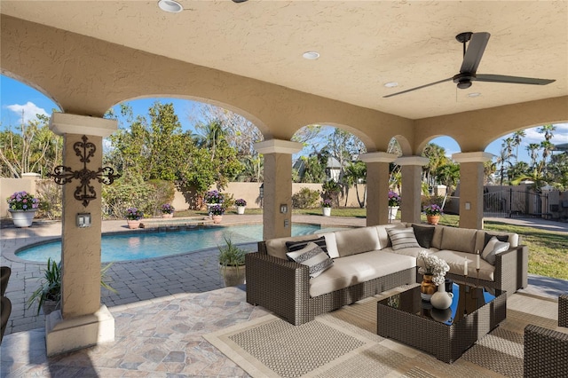 view of patio / terrace with an outdoor living space, a fenced in pool, and ceiling fan