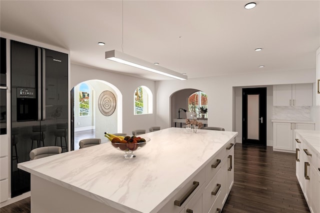 8855 Midnight Pass Rd, Sarasota, FL 34242 - kitchen with arched walkways, a kitchen island, white cabinetry, recessed lighting, and dark wood-style floors