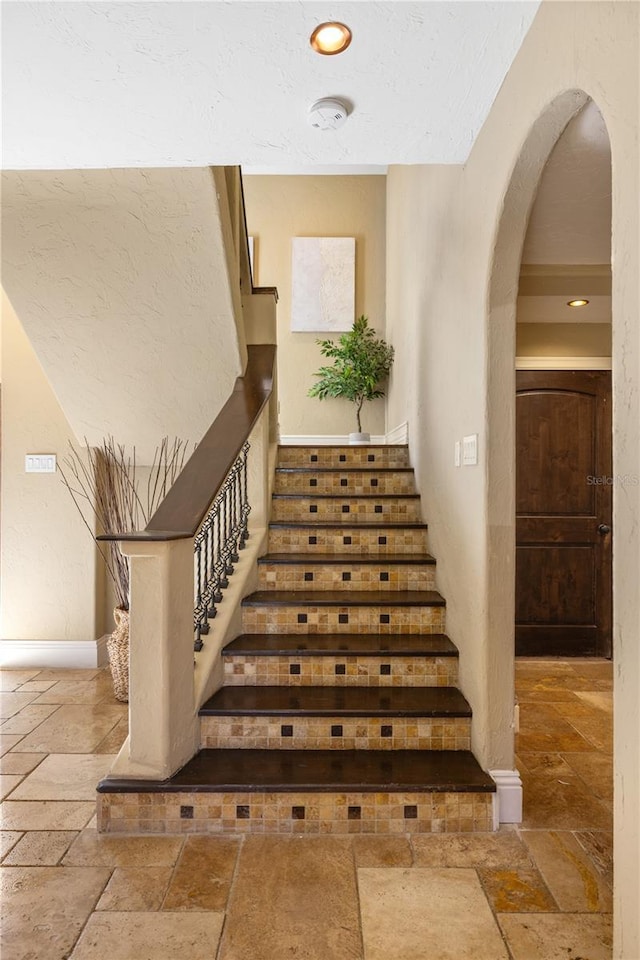 8855 Midnight Pass Rd, Sarasota, FL 34242 - stairs with stone tile flooring, arched walkways, and recessed lighting