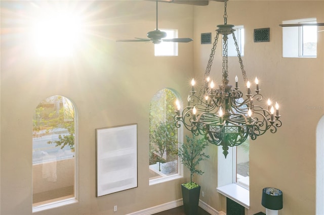 interior details featuring ceiling fan with notable chandelier