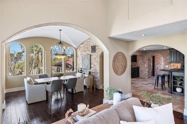 8855 Midnight Pass Rd, Sarasota, FL 34242 - living room with arched walkways, a chandelier, dark wood-style floors, a wood stove, and lofted ceiling