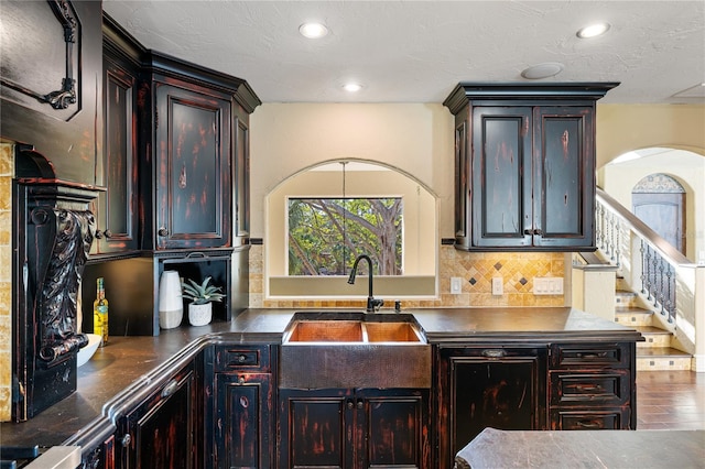 8855 Midnight Pass Rd, Sarasota, FL 34242 - kitchen with backsplash, dark countertops, recessed lighting, arched walkways, and dark brown cabinets