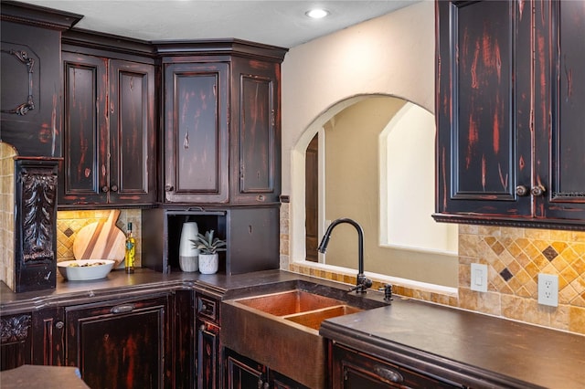 8855 Midnight Pass Rd, Sarasota, FL 34242 - kitchen with dark countertops, backsplash, arched walkways, dark brown cabinets, and recessed lighting