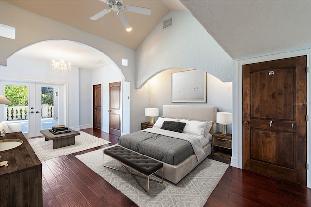 bedroom featuring french doors, dark hardwood / wood-style flooring, ceiling fan with notable chandelier, and vaulted ceiling