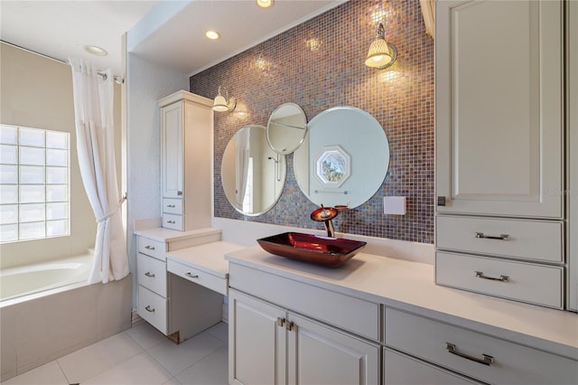 bathroom with tile patterned flooring, vanity, decorative backsplash, and a tub