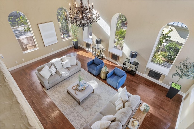 living room featuring dark wood-type flooring, an inviting chandelier, and a healthy amount of sunlight