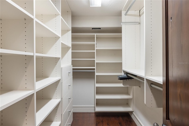 walk in closet with dark wood-type flooring