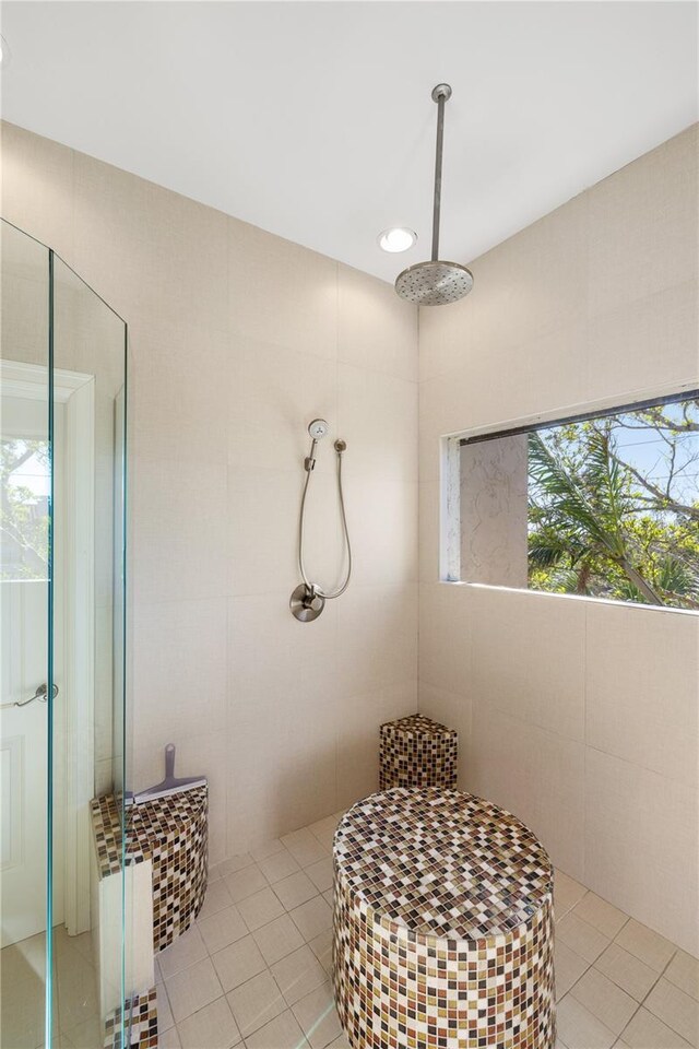 bathroom featuring tile patterned flooring, a shower, and tile walls