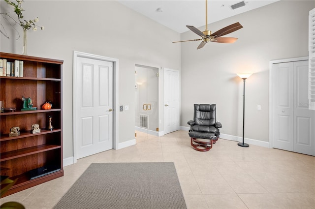 sitting room with high vaulted ceiling, ceiling fan, and light tile patterned flooring