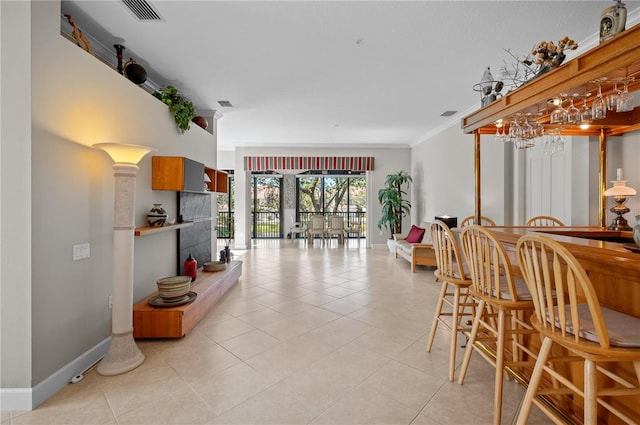 tiled dining area featuring ornamental molding and a fireplace