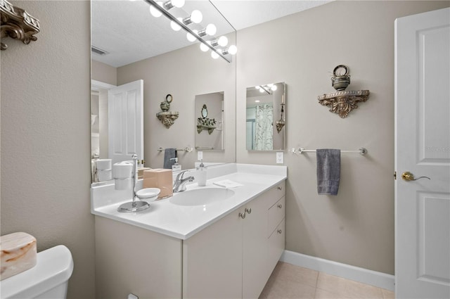 bathroom featuring toilet, a textured ceiling, tile patterned floors, and vanity