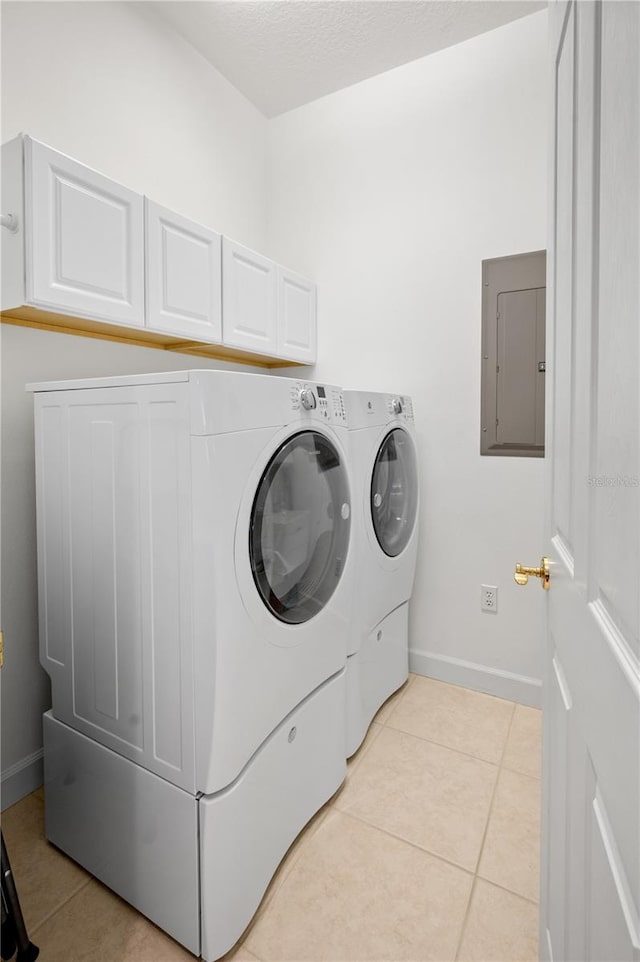 clothes washing area featuring cabinets, separate washer and dryer, light tile patterned floors, and electric panel