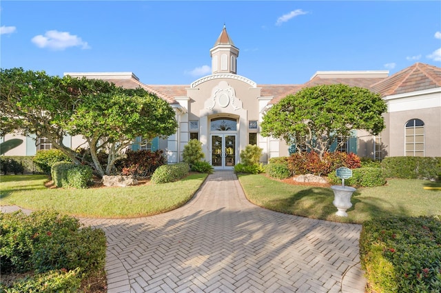 view of front of house featuring a front lawn and french doors