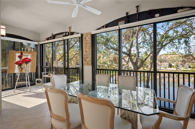 sunroom featuring ceiling fan and a water view