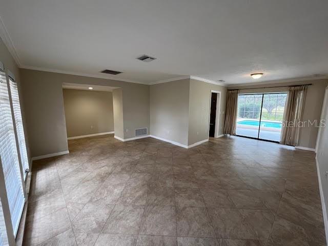 spare room featuring ornamental molding and a healthy amount of sunlight